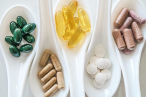 Top view of natural vitamin supplement on white spoon as frame o